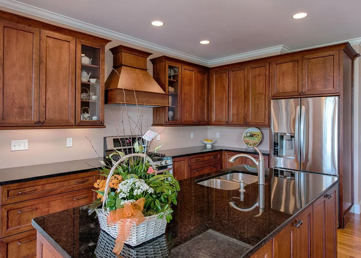 Cherry kitchen with a copper-toned hood and dark granite counters