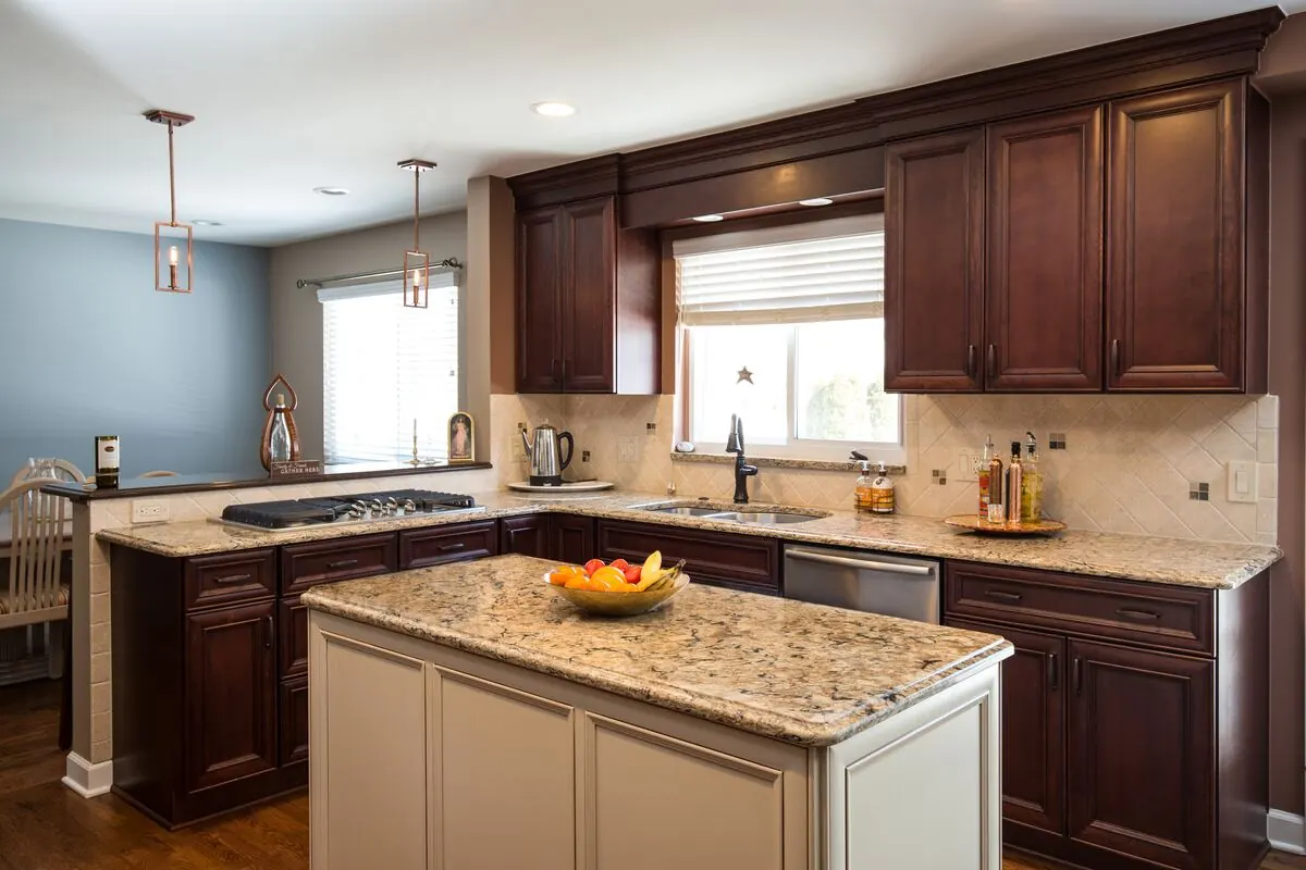 Dark cherry kitchen with a painted island and granite counters