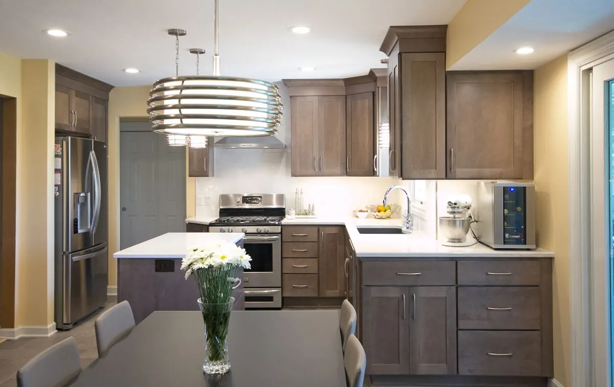 Kitchen in gray-brown stained cabinets beside a dining table