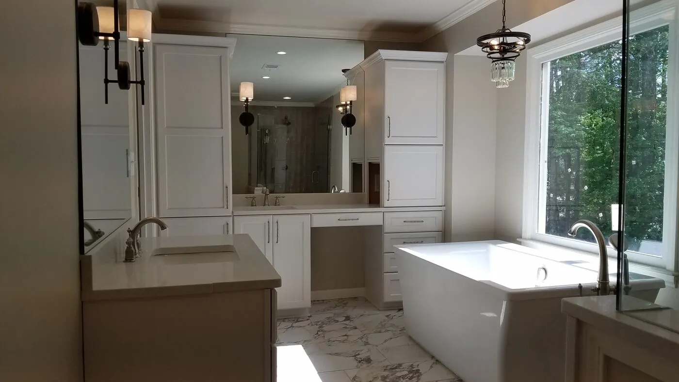 Bright bathroom with white vanity cabinets, a makeup station and tall linen storage